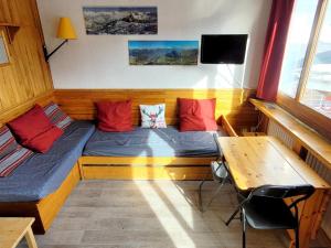 a room with two beds and a table and a desk at Studio La Plagne, 1 pièce, 2 personnes - FR-1-181-2634 in La Plagne Tarentaise