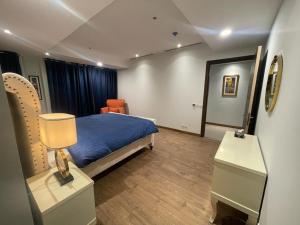 - une chambre avec un lit et une table avec une lampe dans l'établissement Gold crest Mall & Residence, à Lahore