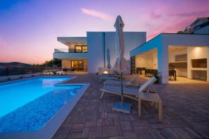 a villa with a swimming pool and a house at Villa Sunčica in Zaboric