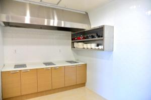 a kitchen with wooden cabinets and a counter top at Seom Guesthouse in Seogwipo