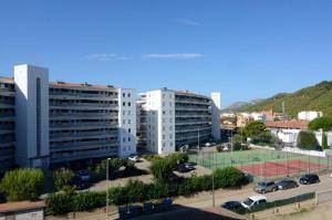 a tennis court in a parking lot with buildings at ROCAMAURA 3 - L'Estartit in L'Estartit