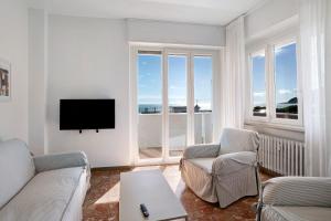 ein Wohnzimmer mit 2 Sofas und einem Flachbild-TV in der Unterkunft Fronte Mare - Marina di Andora in Marina dʼAndora