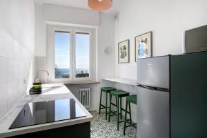 eine Küche mit einem Kühlschrank und einigen grünen Stühlen in der Unterkunft Fronte Mare - Marina di Andora in Marina dʼAndora