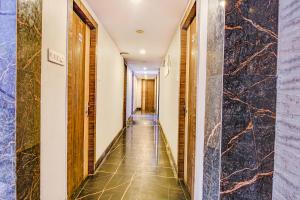 um corredor de um hotel com paredes de mármore em FabExpress Subh Residency em Sāntrāgāchi