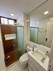 a bathroom with a toilet and a sink and a mirror at Ótima Localização - Zona Norte - SEM TAXAS in Recife