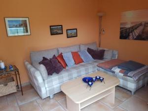 uma sala de estar com um sofá e uma mesa em Eikkater 4 EG em Graal-Müritz