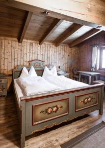 a large bed in a room with wooden walls at Chalet Edelweiß in Saalbach-Hinterglemm