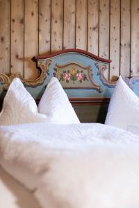 a close up of a bed with white sheets and pillows at Chalet Edelweiß in Saalbach-Hinterglemm