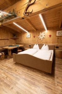 a bedroom with a large bed in a wooden room at Chalet Edelweiß in Saalbach-Hinterglemm
