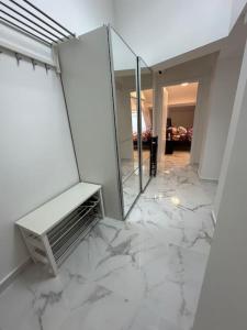 Habitación blanca con suelo de mármol y espejo. en Cozy apartment in Monaco center, en Montecarlo