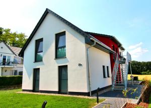 uma casa com uma fachada vermelha e branca em Luxus_EG_Fewo TEE ONE em Göhren-Lebbin
