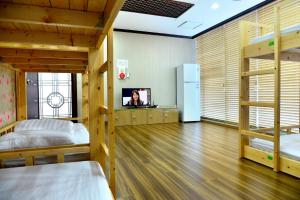 a room with two bunk beds and a tv at Seom Guesthouse in Seogwipo