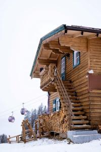 a log cabin with a staircase in the snow at Chalet Edelweiß in Saalbach-Hinterglemm