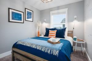 Un dormitorio con una cama con sábanas azules y una ventana. en 962 Townhouse 3BR Near Downtown Beaches and Wineries, en Traverse City 79 fotos más