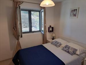 een slaapkamer met een bed met twee kussens erop bij Robinson Ane in Gdinj