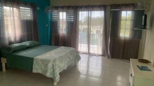 una camera con un letto in una stanza con finestre di The Resort at West End a Negril