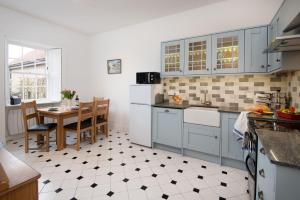 a kitchen with blue cabinets and a table in it at Windyrig in Cockburnspath