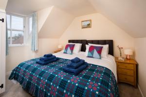 a bedroom with a bed with blue pillows on it at Windyrig in Cockburnspath