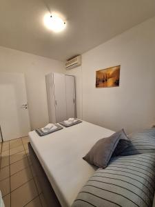 a bedroom with a large white bed and a cabinet at DIN2 Ljubic in Mimice