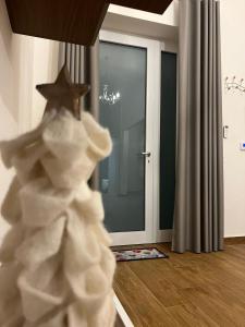 Un albero di Natale giocattolo davanti a una porta di AS Apartment a Frattamaggiore