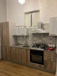 una cucina con lavandino e piano cottura forno superiore di AS Apartment a Frattamaggiore