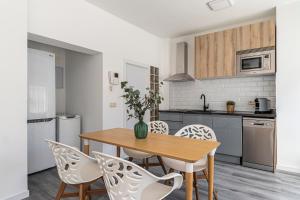 a kitchen with a wooden table and chairs at BNBHolder Calm Duplex Retiro Free Parking in Madrid