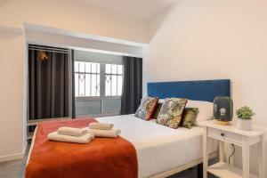 a bedroom with a bed with towels on it at BNBHolder Calm Duplex Retiro Free Parking in Madrid