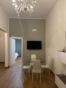 una sala da pranzo con tavolo, sedie e TV di AS Apartment a Frattamaggiore