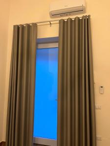 una tenda davanti a una finestra con una luce blu di AS Apartment a Frattamaggiore