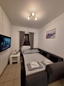 a room with a bed and a couch and a tv at DIN2 Ljubic in Mimice