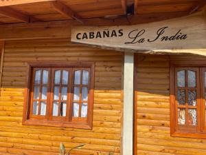 ein Schild an der Seite eines Holzgebäudes in der Unterkunft Cabañas “La India” in Jardín América
