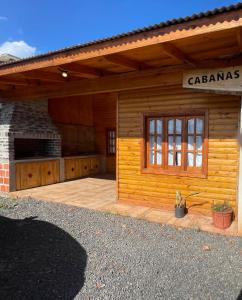 a wooden cabin with a large patio in front of it at Cabañas “La India” in Jardín América