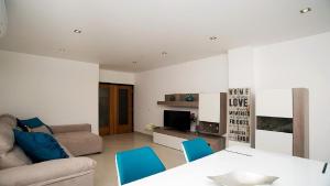 - un salon avec un canapé, une table et des chaises dans l'établissement Apartamento Oura Mar - By Dalma Portuguesa, à Albufeira