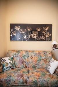 ein Sofa in einem Zimmer mit einem Gemälde an der Wand in der Unterkunft Villa Aldo e Lalla in Rozzano