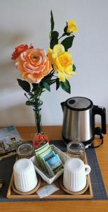 un jarrón lleno de flores sentado sobre una mesa en HOCHDÜRRNBERG WATZMANN Doppelzimmer mit Bad Balkon Gästeküche - Frühstück optional en Dürrnberg