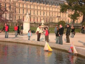 a group of people playing with toy boats in the water at Maison des Peupliers in Bondy