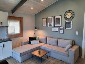 a living room with a couch and a clock on the wall at Thasos Bespoke Haven - Meltemi Summer Retreat! in Limenaria