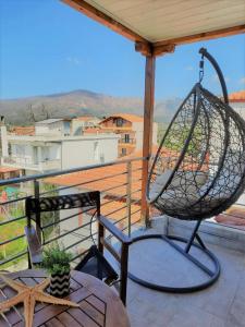 a swing on a balcony with a view of a city at Thasos Bespoke Haven - Meltemi Summer Retreat! in Limenaria