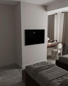 een hotelkamer met een flatscreen-tv aan de muur bij Dastan Hotel Baku in Baku