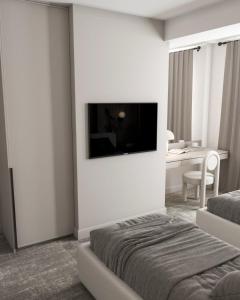 a hotel room with a bed and a television on a wall at Dastan Hotel Baku in Baku
