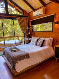 ein Schlafzimmer mit einem großen Bett in einer Hütte in der Unterkunft Cambará Ecomoradas in Cambará