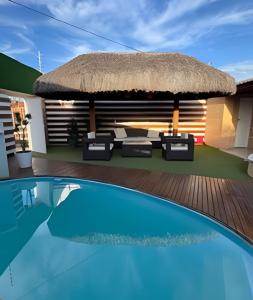 a resort with a swimming pool and a thatch hut at Casa de Praia Tibau-RN in Tibau