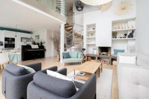 una sala de estar con 2 sofás y un piano en Villa Corneille - Welkeys, en Versalles