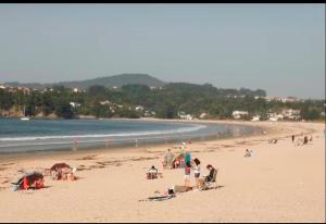 a group of people on a beach near the water at La coruña Sas playa y golf in Paderne