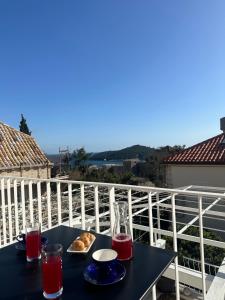 una mesa negra con comida y bebida en el balcón en Guest House Katić, en Dubrovnik