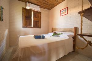 a bedroom with a bed with a table and a window at Pousada Azul com vistas maravilhosas in Cumuruxatiba