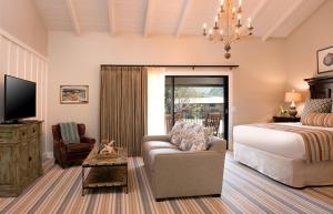 a bedroom with a bed and a couch and a tv at The Ranch at Laguna Beach in Laguna Beach