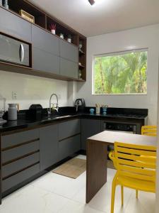 una cocina con mesa y sillas amarillas. en Casa com pier e área gourmet., en Angra dos Reis