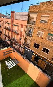 a white bench on a balcony in front of a building at Cute and Cosy habitación privada con balcón in Valencia