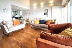 a living room with two couches and a kitchen at Clearwater 31, The Lakehouse in Somerford Keynes